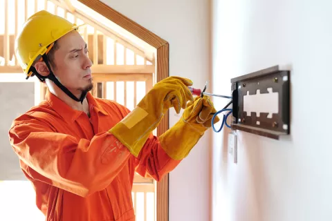 Ein Installateur schraubt eine Wandhalterung für einen Zweirichtungszähler an.